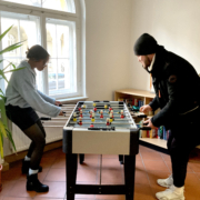 Eine Schülerin und ein Schüler spielen Tischfußball im Gemeinschaftsraum