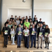 Schülerinnen und Schüler stehen mit dem Landrat in einer Aula und halten die ersten Broschüren des Ausbilduns-Navi