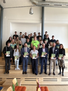 Staatl. Regelschule J. Dicel Seebach Schülerinnen und Schüler stehen mit dem Landrat in einer Aula und halten die ersten Broschüren des Ausbilduns-Navi